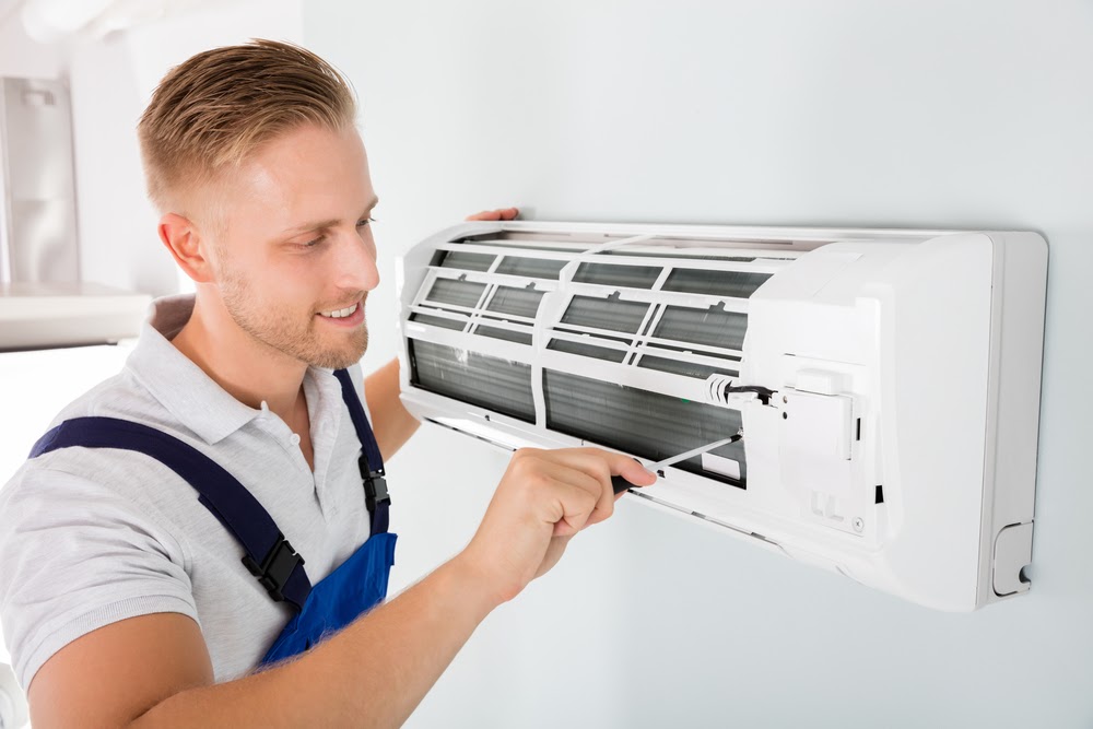 man fixing ductless mini-split ac unit