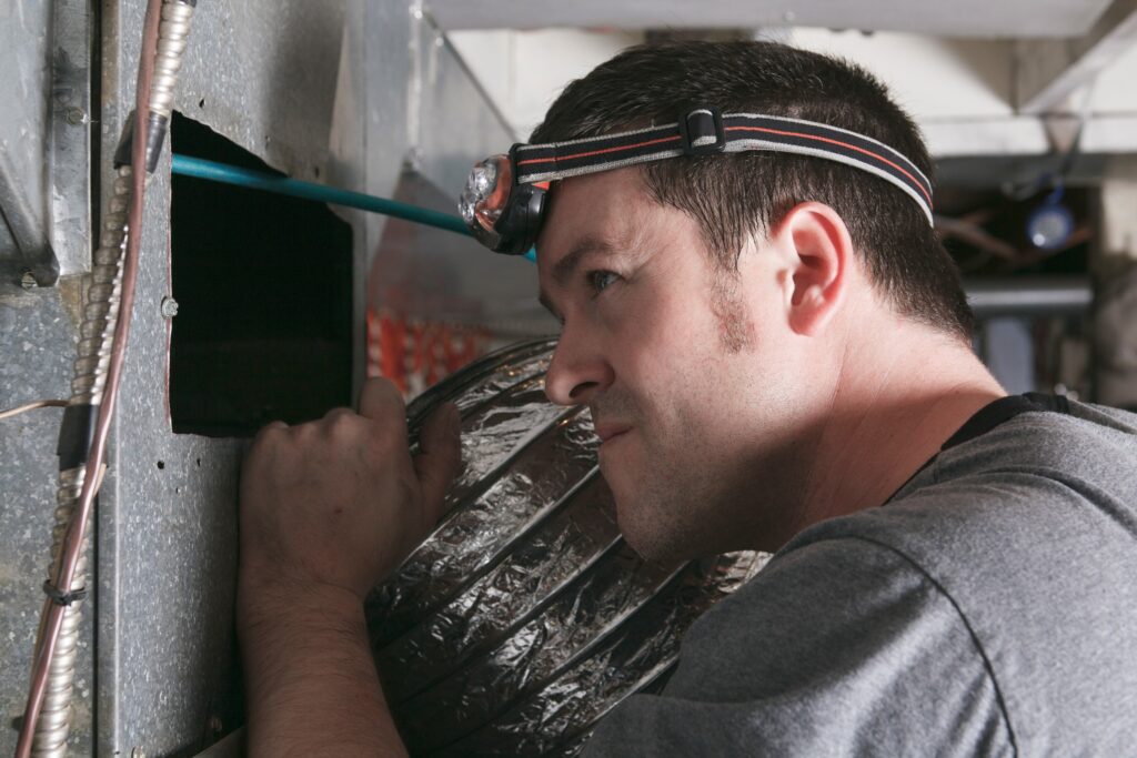hvac tech inspecting furnace making weird noise